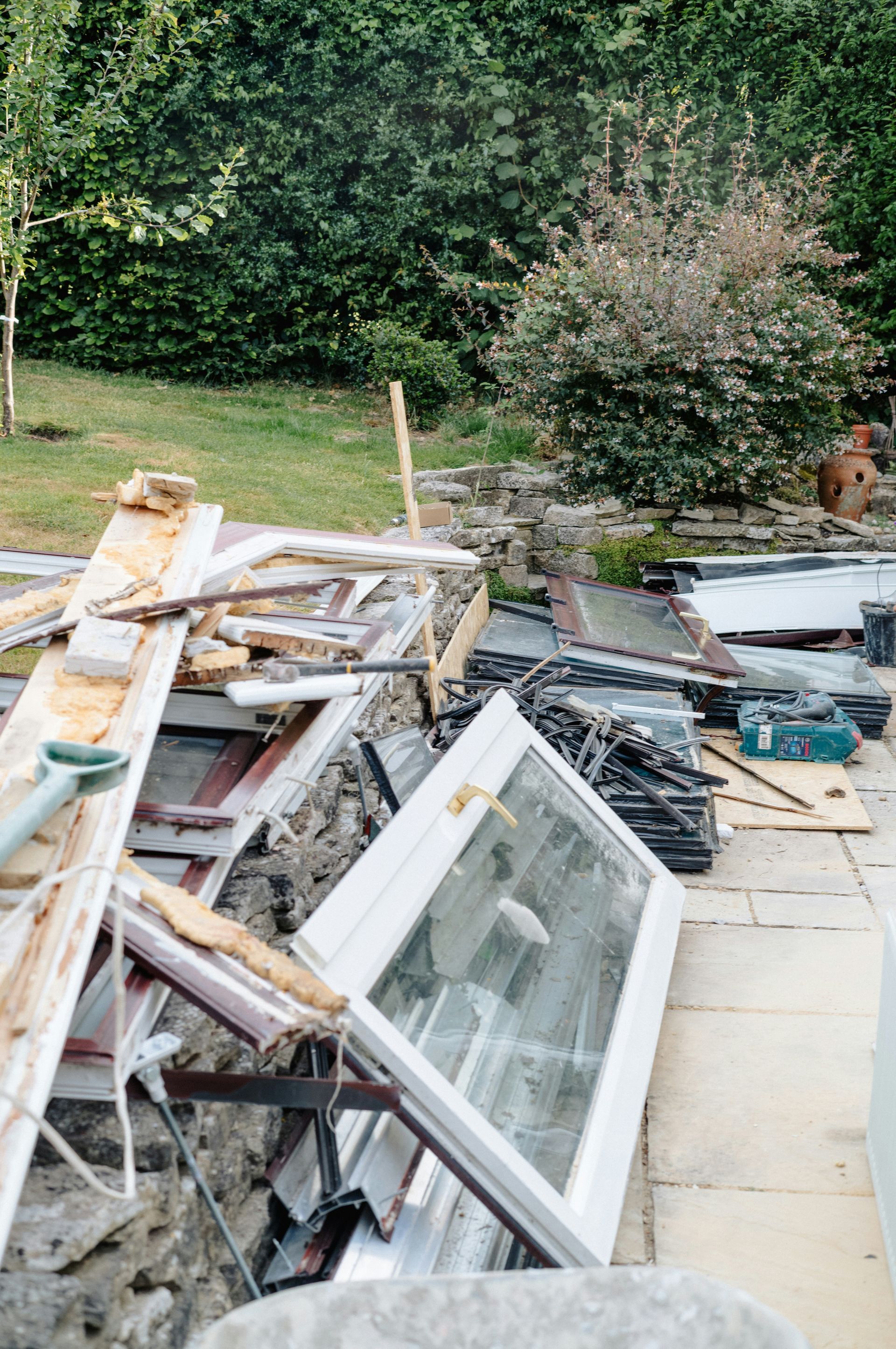 Discarded window frames and construction waste in yard